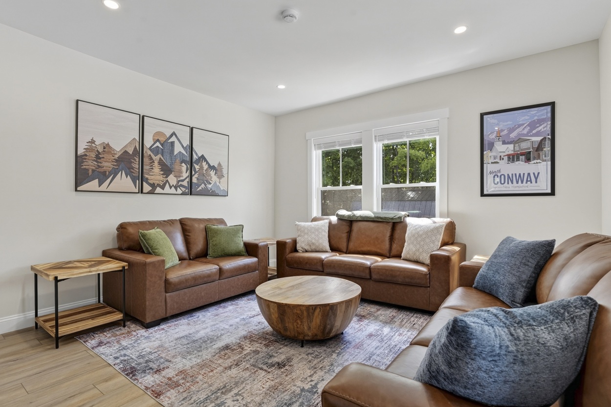 Big open-concept living room with three couches and a 70-inch TV