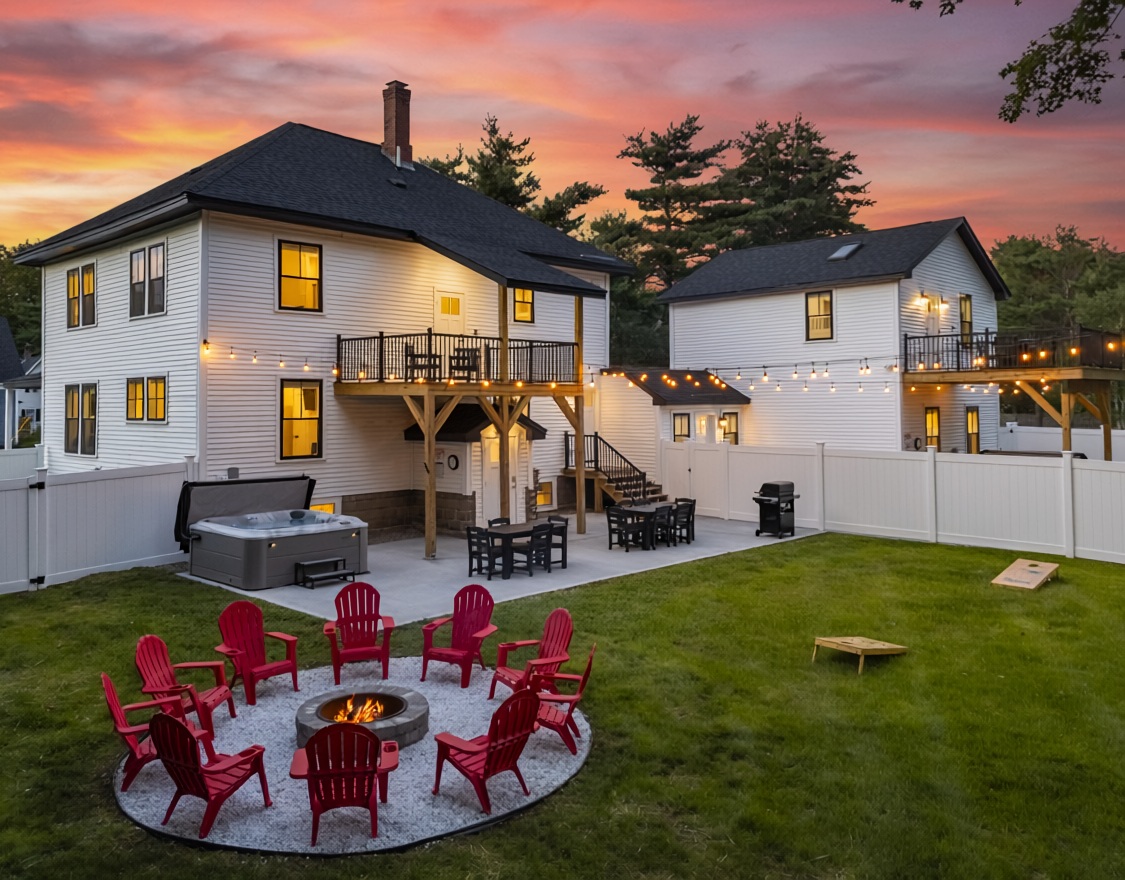 Fenced backyard with fire pit, grill, yard games and bistro lights